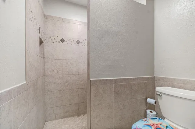 a white toilet sitting next to a bathroom sink and a shower