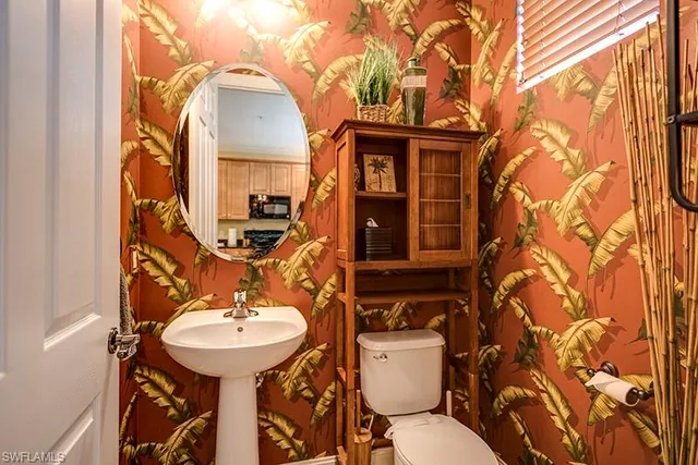 a bathroom with a sink and mirror with toilet
