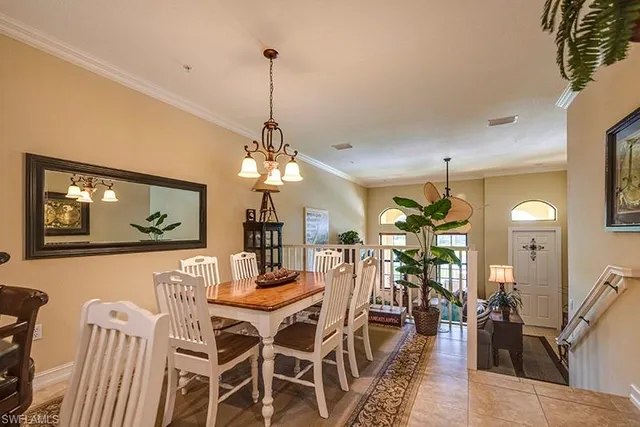 a view of a dining room and livingroom with furniture wooden floor a rug a painting and a chandelier