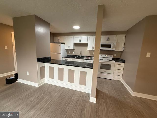 19513 Gunners Branch Road, Unit 514 Germantown, MD 20876 - Photo 11 of 42 a kitchen with stainless steel appliances kitchen island granite countertop a stove a sink and white cabinets with wooden floor