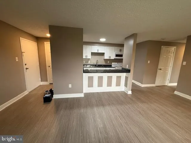a view of kitchen with stainless steel appliances wooden floor and window