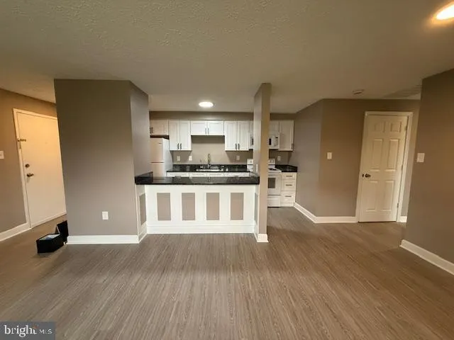 a large kitchen with a wooden floor and stainless steel appliances