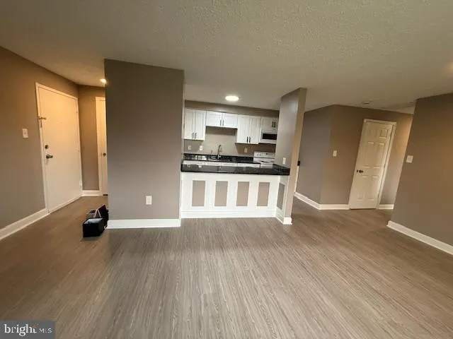 a kitchen with granite countertop a stove a sink and a refrigerator