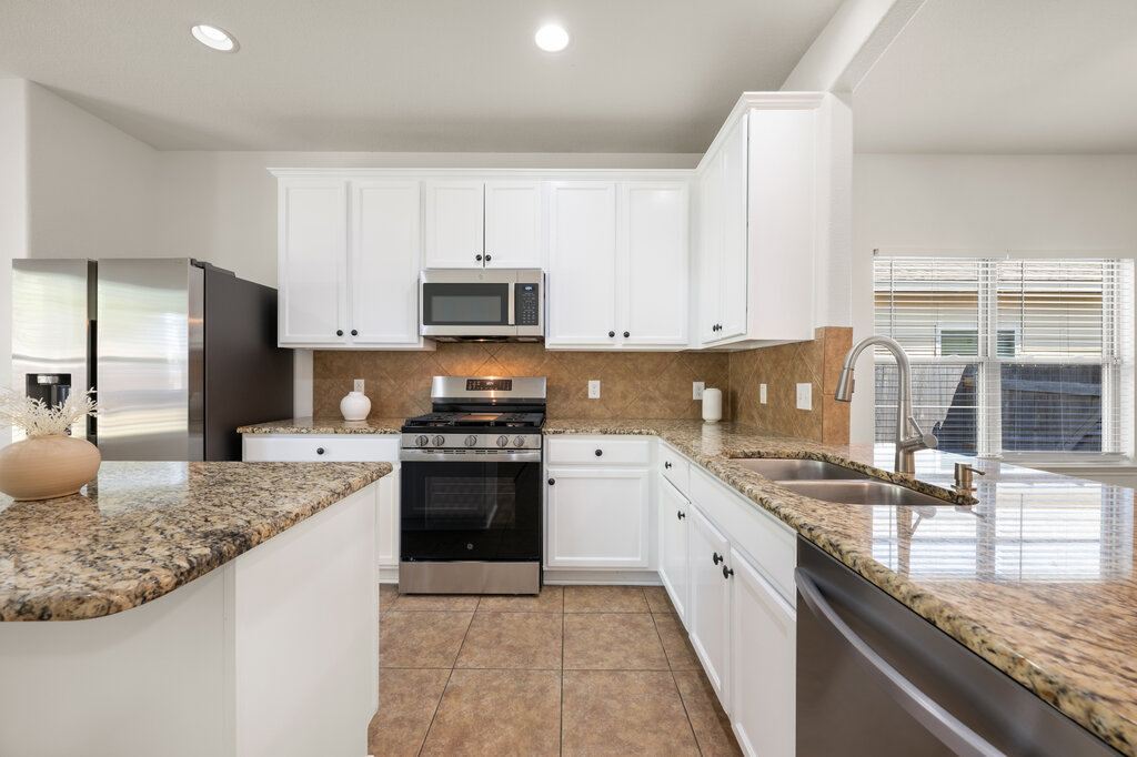 11744 Easy Street Austin, TX 78748 - Photo 18 of 40 Polished granite countertops and classic tile flooring define this bright, open kitchen workspace.