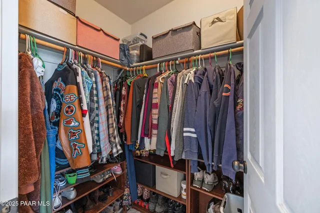 a view of walk in closet with clothes and shoes