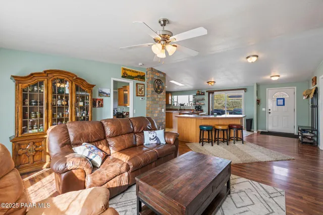 a kitchen with stainless steel appliances granite countertop a dining table chairs and a large window