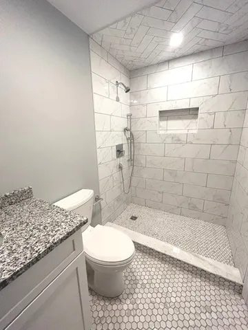 a bathroom with a granite countertop bathtub and toilet