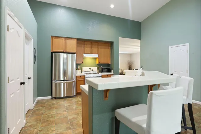 a kitchen with a table chairs sink and cabinets
