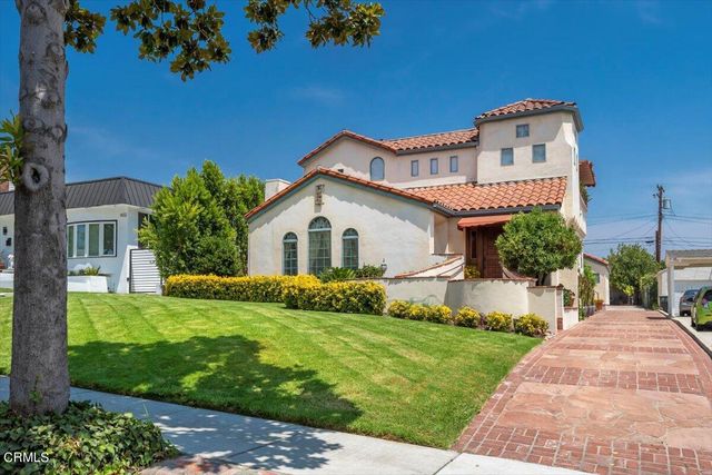a view of a house with a yard and potted plants