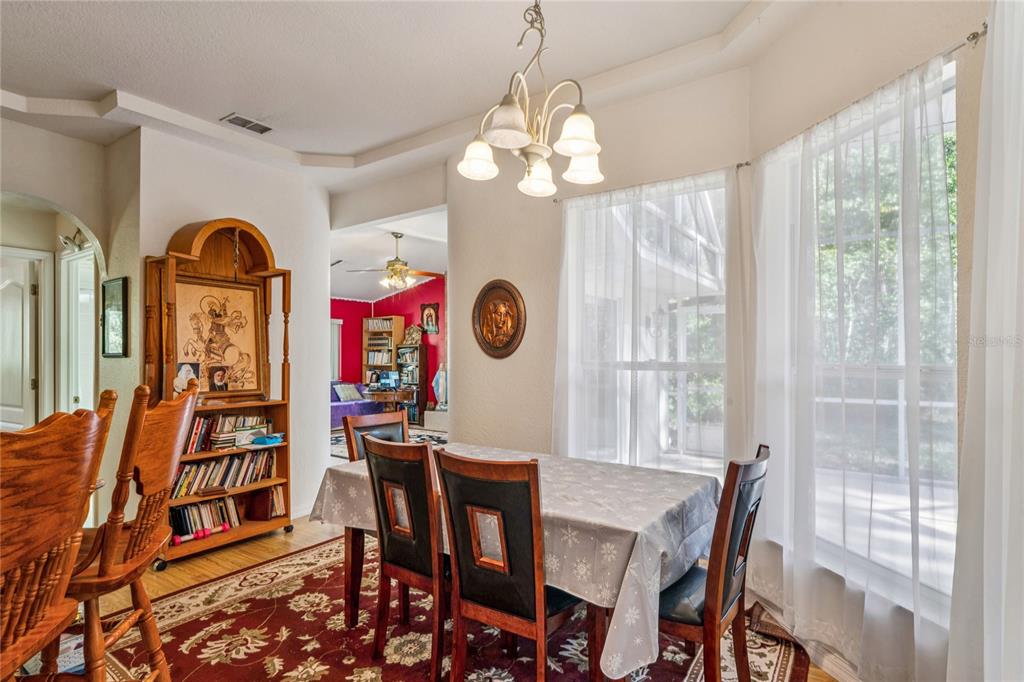 26861 Mondon Hill Road Brooksville, FL 34602 - Photo 11 of 51 a view of a dining room with furniture wooden floor and chandelier