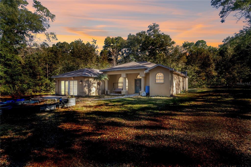 26861 Mondon Hill Road Brooksville, FL 34602 - Photo 2 of 51 a front view of a house with a garden