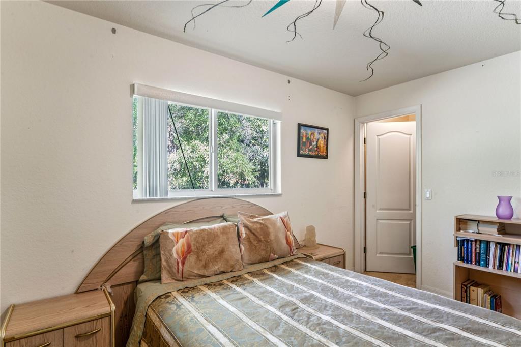 26861 Mondon Hill Road Brooksville, FL 34602 - Photo 24 of 51 a bedroom with a bed and a book shelf