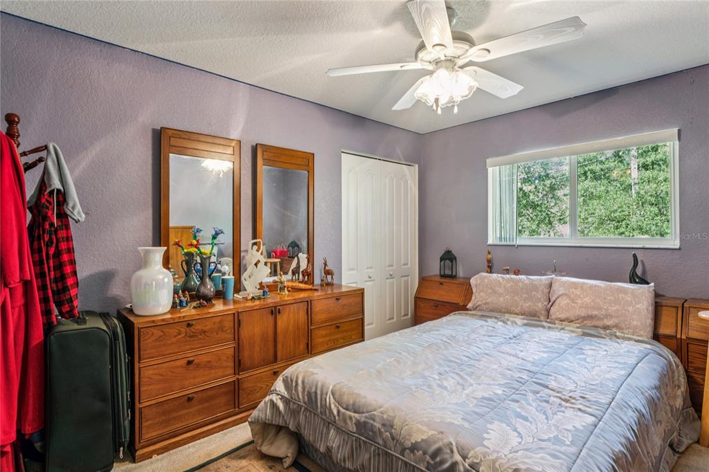 26861 Mondon Hill Road Brooksville, FL 34602 - Photo 27 of 51 a bedroom with a large bed and a chandelier fan