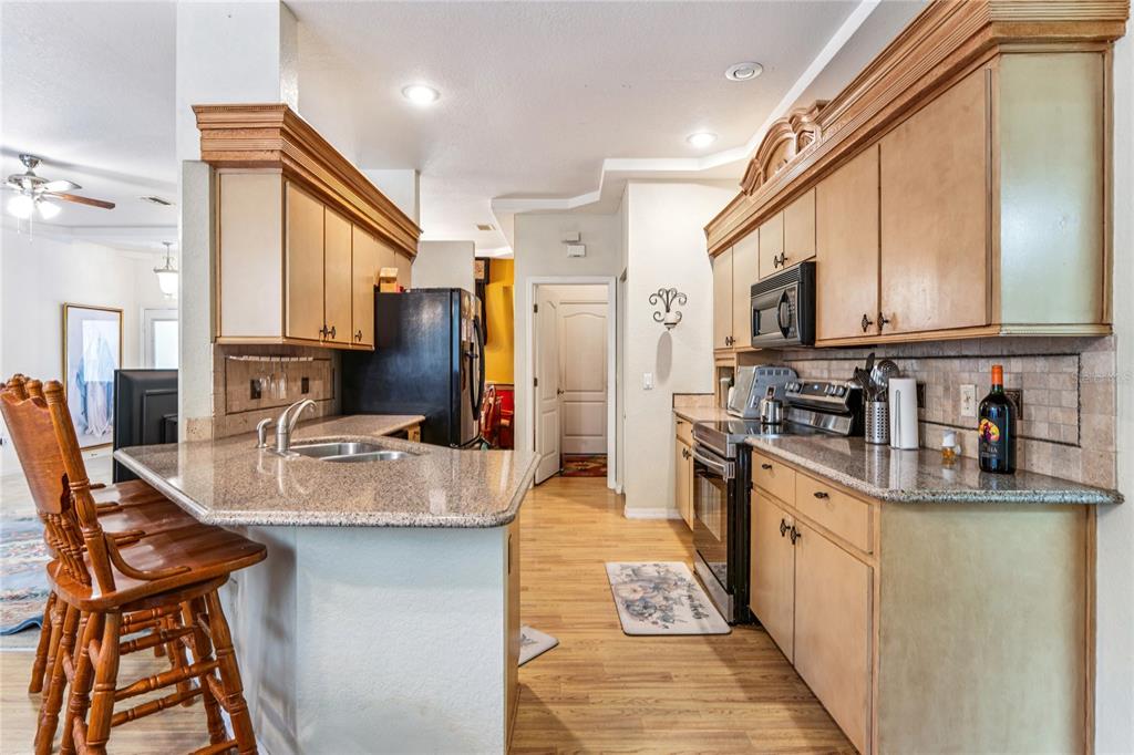 26861 Mondon Hill Road Brooksville, FL 34602 - Photo 9 of 51 a kitchen with stainless steel appliances granite countertop a refrigerator and a stove top oven