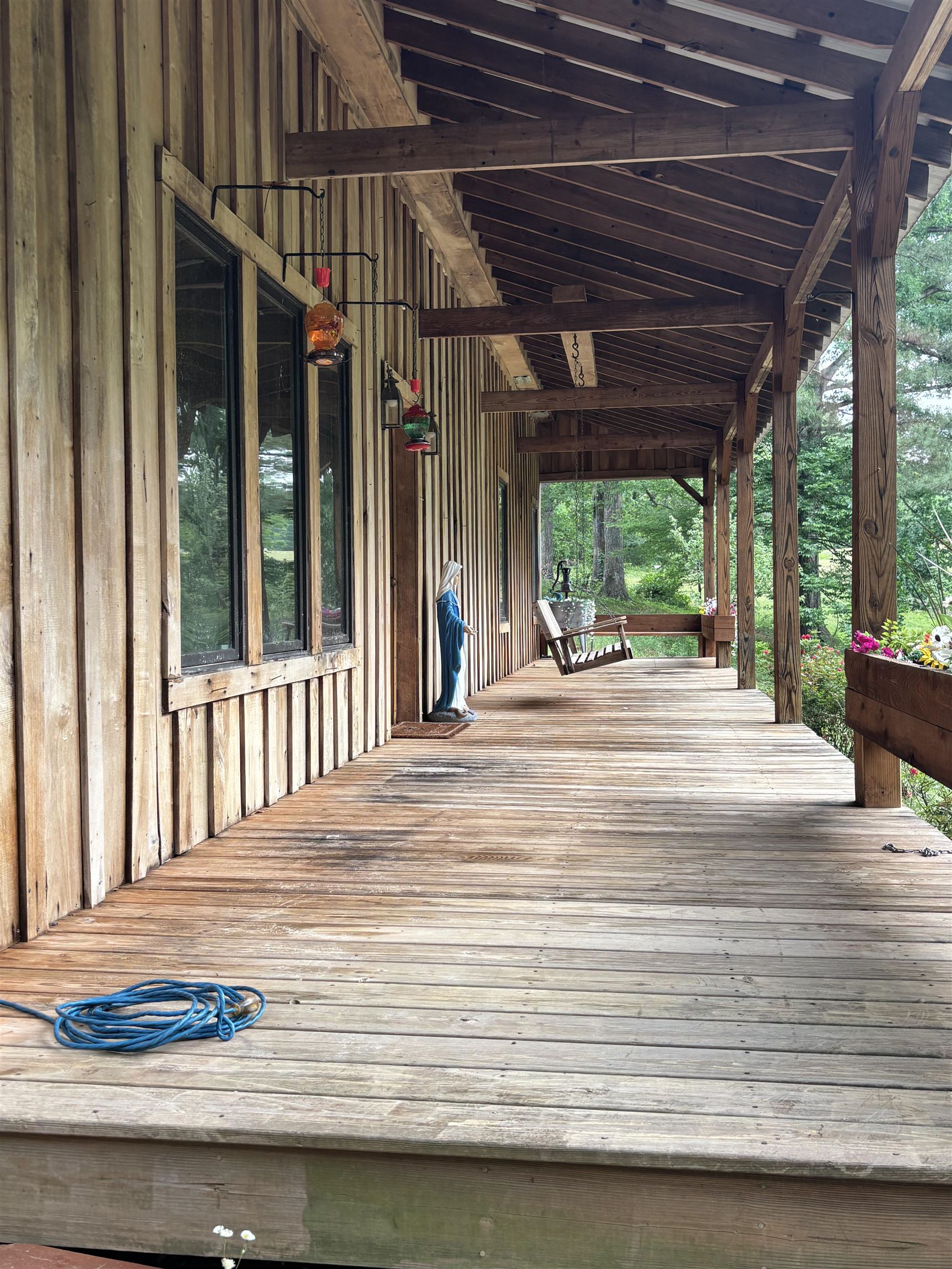 7462 Campground Road Drummonds, TN 38023 - Photo 4 of 31 Expansive wood plank porch with a natural wood-finish ceiling, exposed beams, and board-and-batten siding