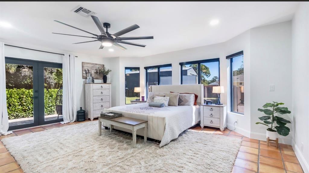 17191 38th Road North Loxahatchee, FL 33470 - Photo 18 of 60 a bedroom with a large bed and a chandelier