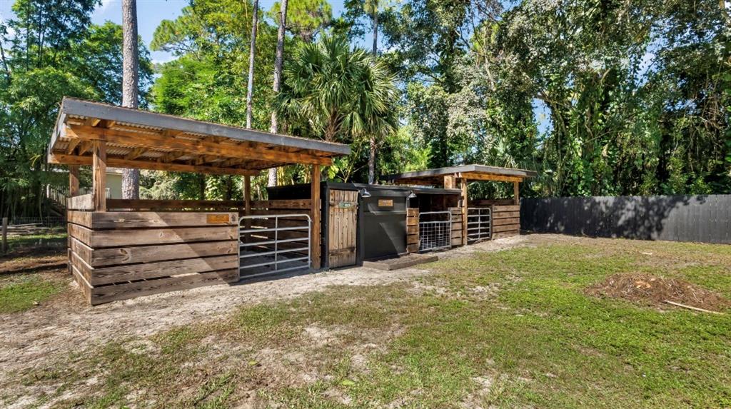 17191 38th Road North Loxahatchee, FL 33470 - Photo 57 of 60 a view of a backyard with wooden fence and large trees