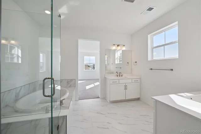 a spacious bathroom with a granite countertop sink a toilet and shower