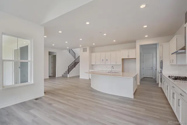 a view of kitchen with kitchen island wooden floors appliances and center island