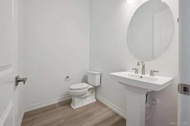 a bathroom with a toilet a sink and a mirror