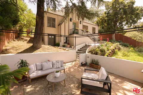 a view of a patio with couches table and chairs and potted plants