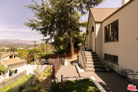 a view of a backyard with table and chairs and potted plants