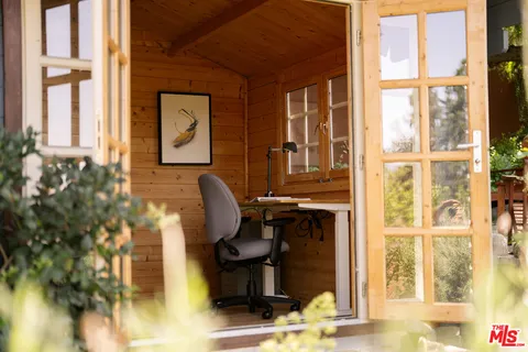 a view of a workspace with furniture and a window