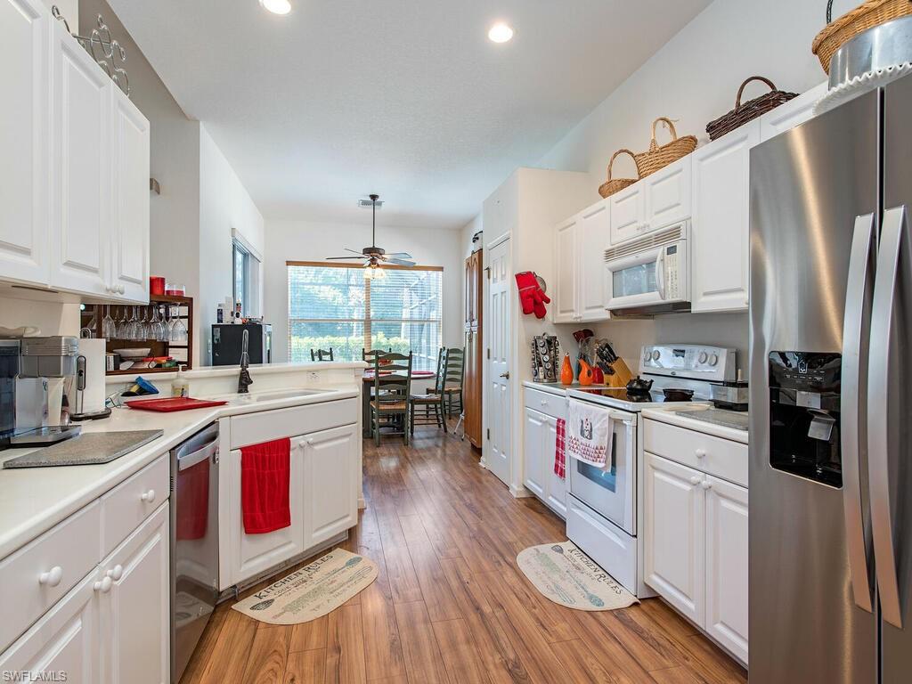 7896 Founders Circle Naples, FL 34104 - Photo 5 of 12 a kitchen with stainless steel appliances granite countertop a stove and a refrigerator
