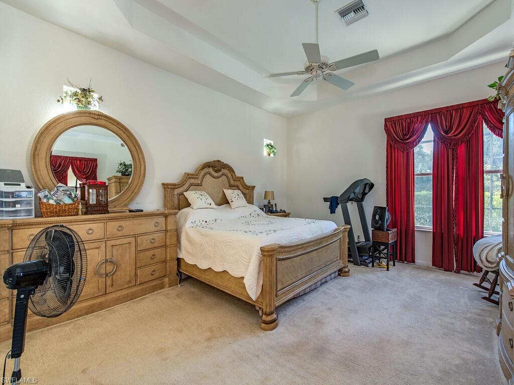 7896 Founders Circle Naples, FL 34104 - Photo 6 of 12 a spacious bedroom with a bed a dresser and mirror