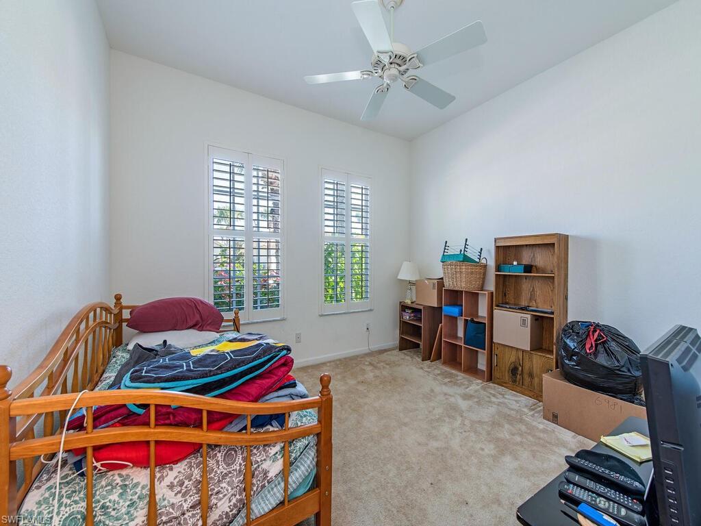 7896 Founders Circle Naples, FL 34104 - Photo 8 of 12 a bedroom with furniture and a bed