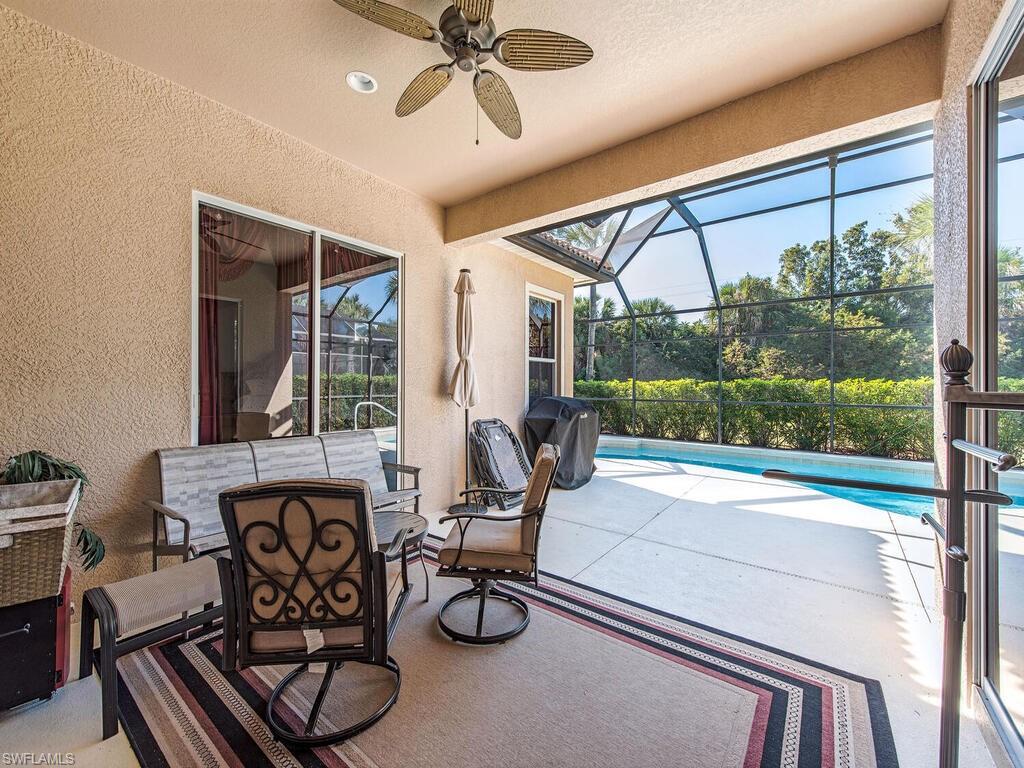 7896 Founders Circle Naples, FL 34104 - Photo 10 of 12 a living room with furniture a floor to ceiling window and a flat screen tv