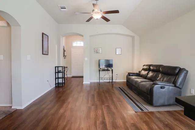 a living room with furniture and a wooden floor