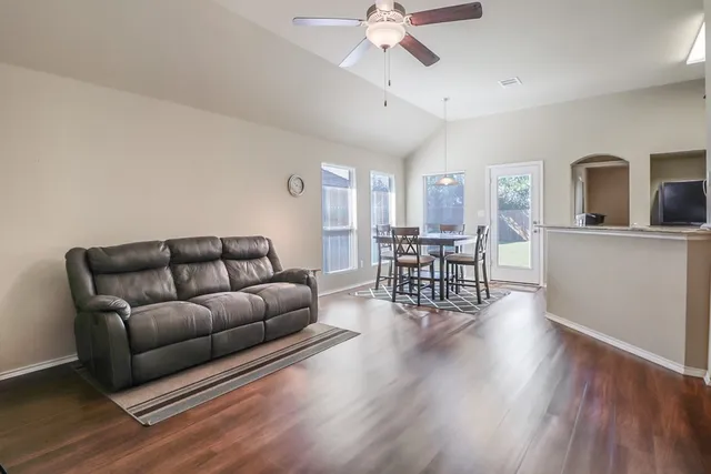 a living room with furniture and wooden floors