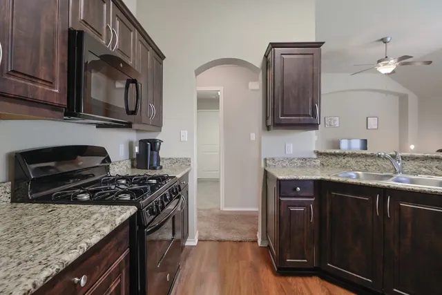 a kitchen with stainless steel appliances granite countertop a stove and a sink