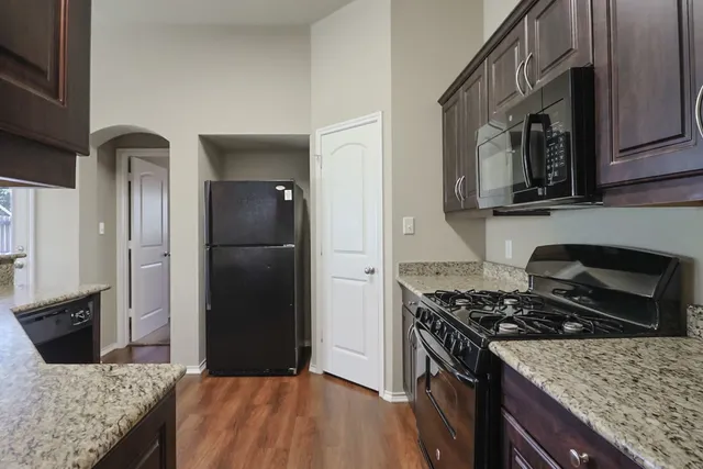 a kitchen with granite countertop stainless steel appliances and wooden cabinets