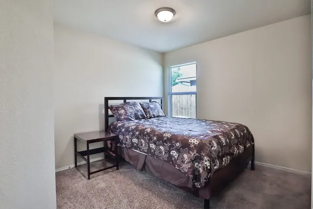 a bed sitting in a bedroom next to a window