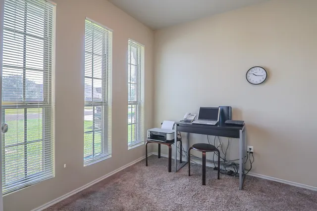 a view of a workspace with furniture and a window