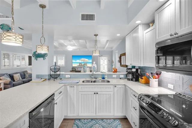 a large kitchen with kitchen island a island a sink a stove and wooden floors