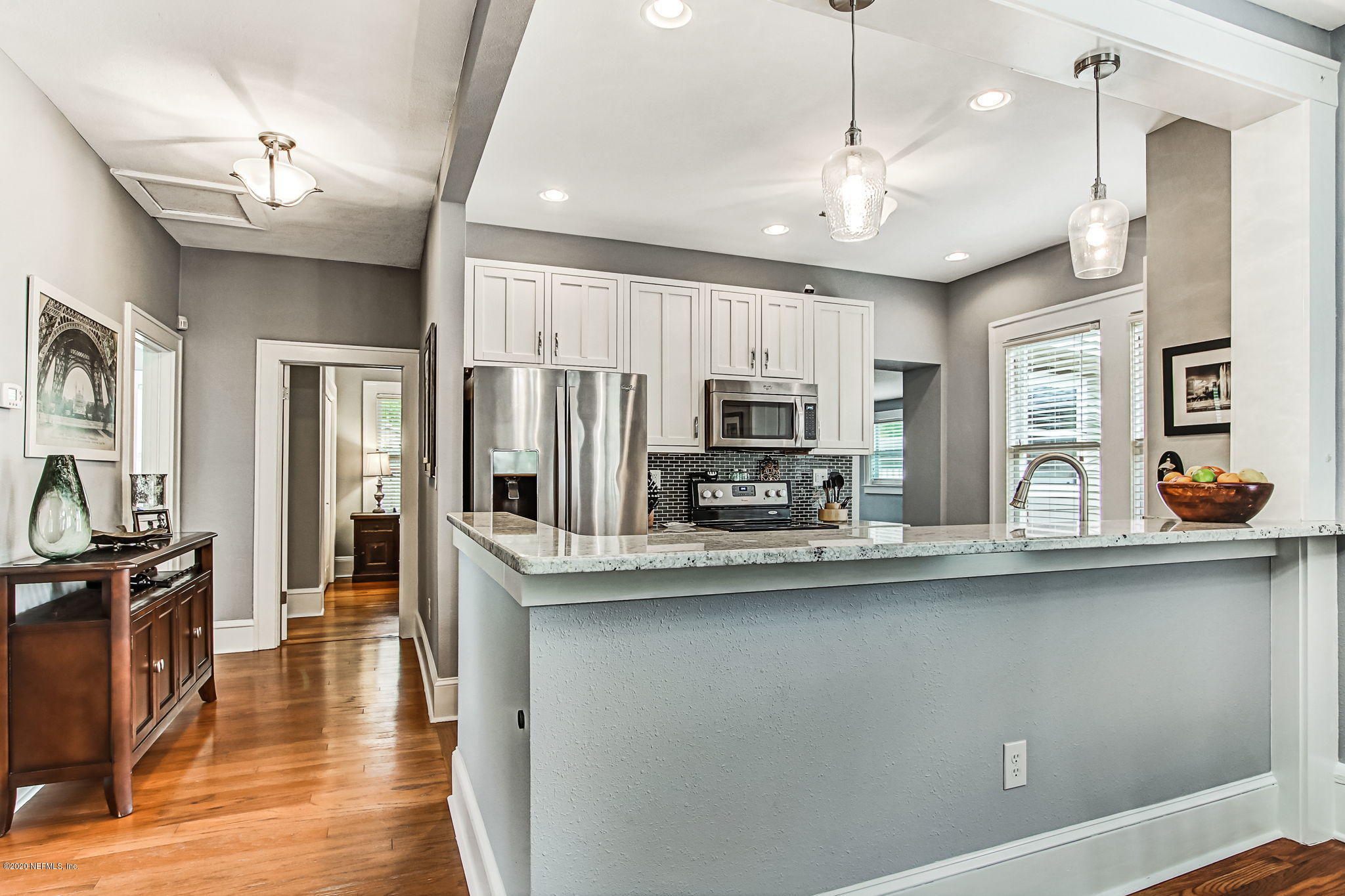 1292 Wolfe Street Jacksonville, FL 32205 - Photo 16 of 38 a kitchen with stainless steel appliances kitchen island granite countertop a refrigerator a sink dishwasher a oven and a dining table with wooden floor