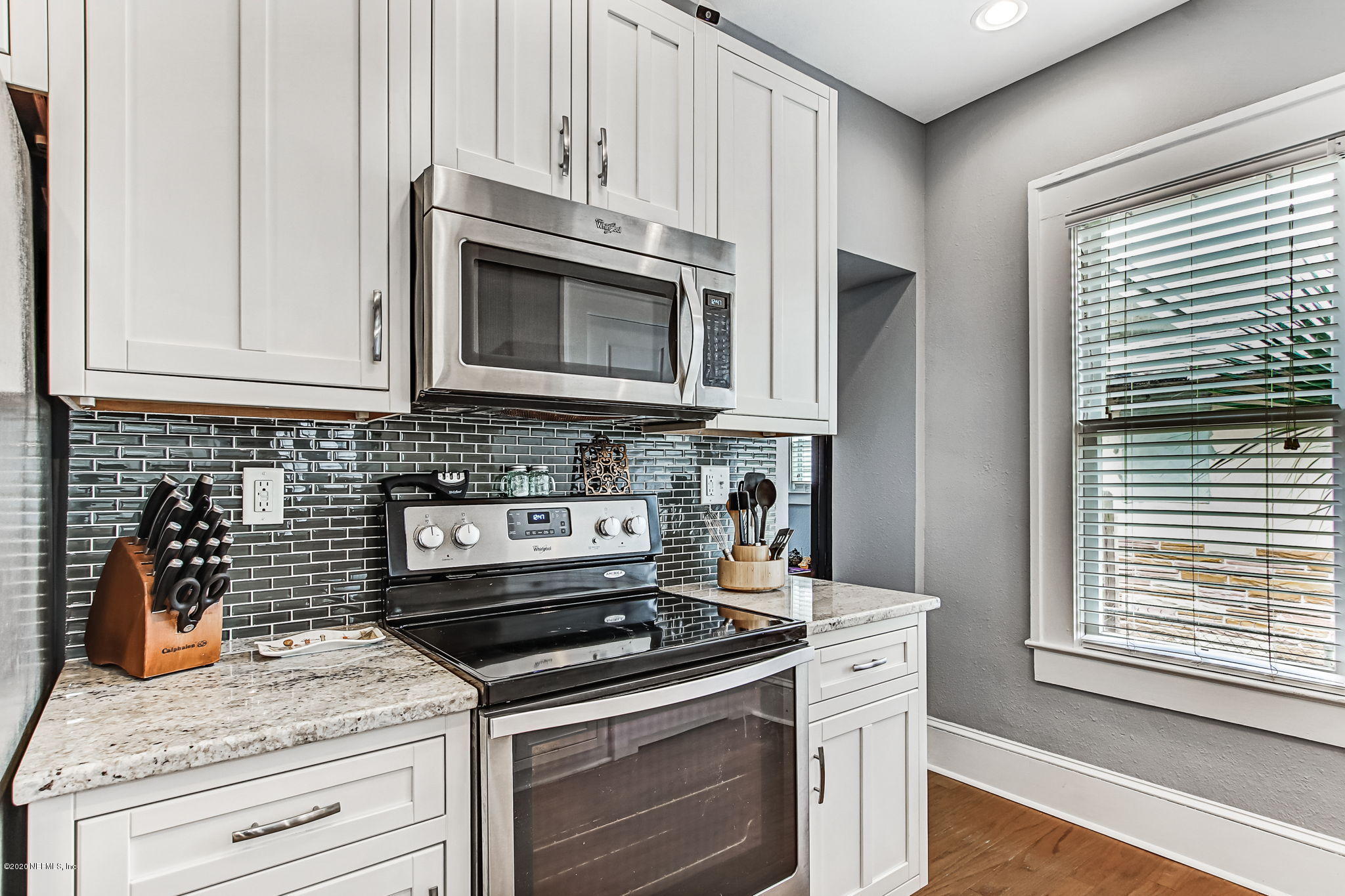 1292 Wolfe Street Jacksonville, FL 32205 - Photo 21 of 38 a kitchen with granite countertop white cabinets and appliances