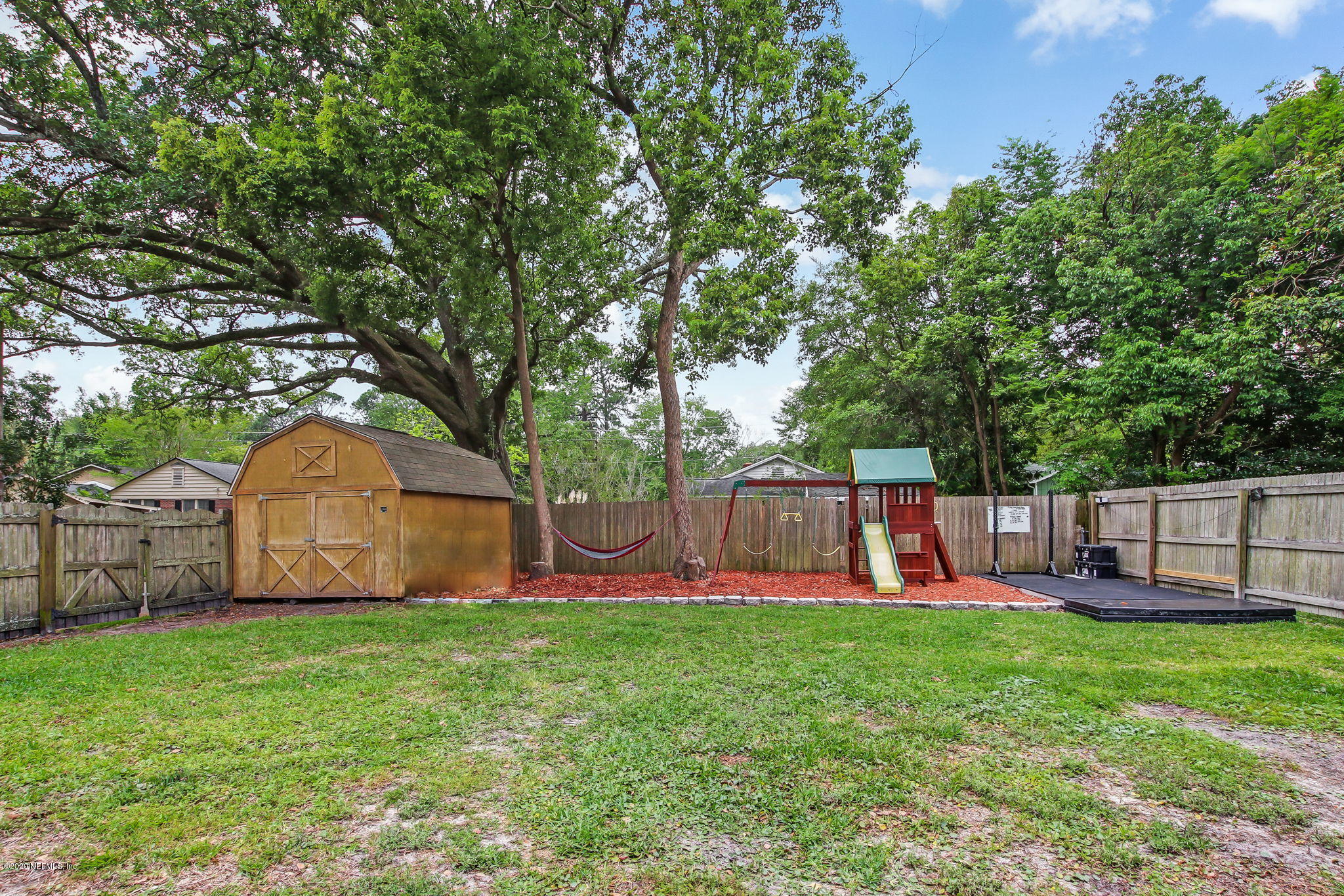 1292 Wolfe Street Jacksonville, FL 32205 - Photo 36 of 38 a view of a yard with large trees and wooden fence