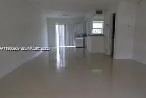 a view of a hallway with wooden floor and a cabinet