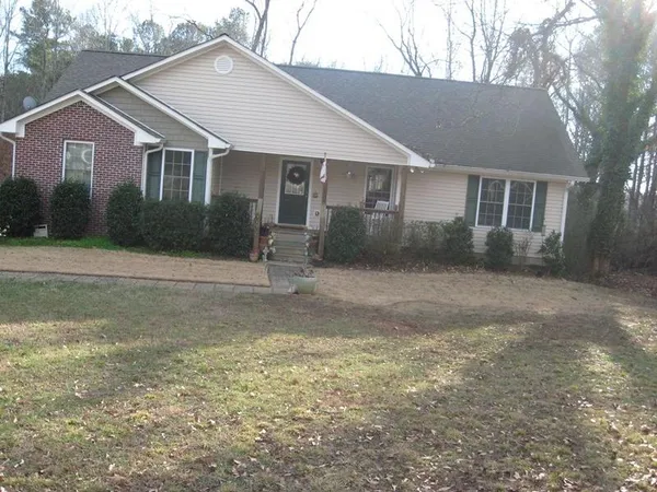a front view of a house with a yard and trees