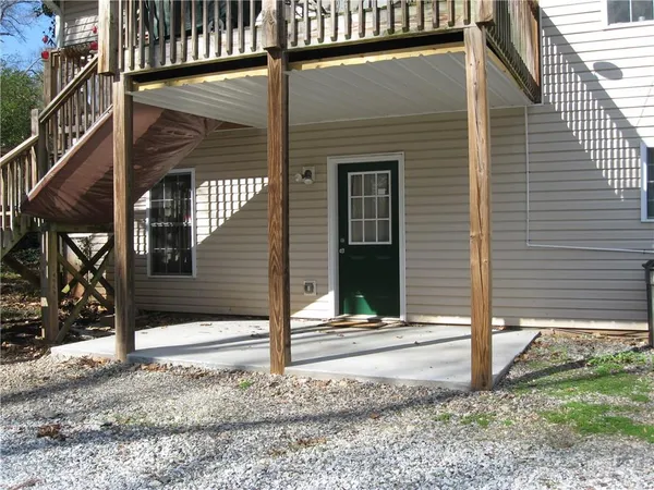 a view of a house with a door and wooden fence