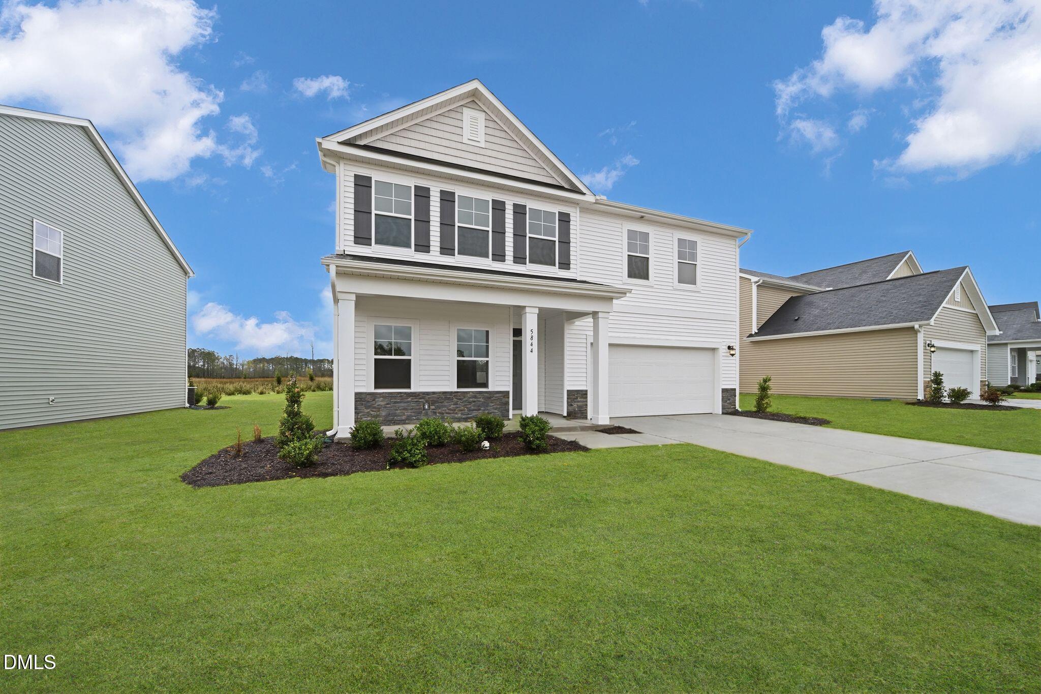 5844 Millstone Way Sims, NC 27880 - Photo 2 of 34 a front view of a house with a garden and yard