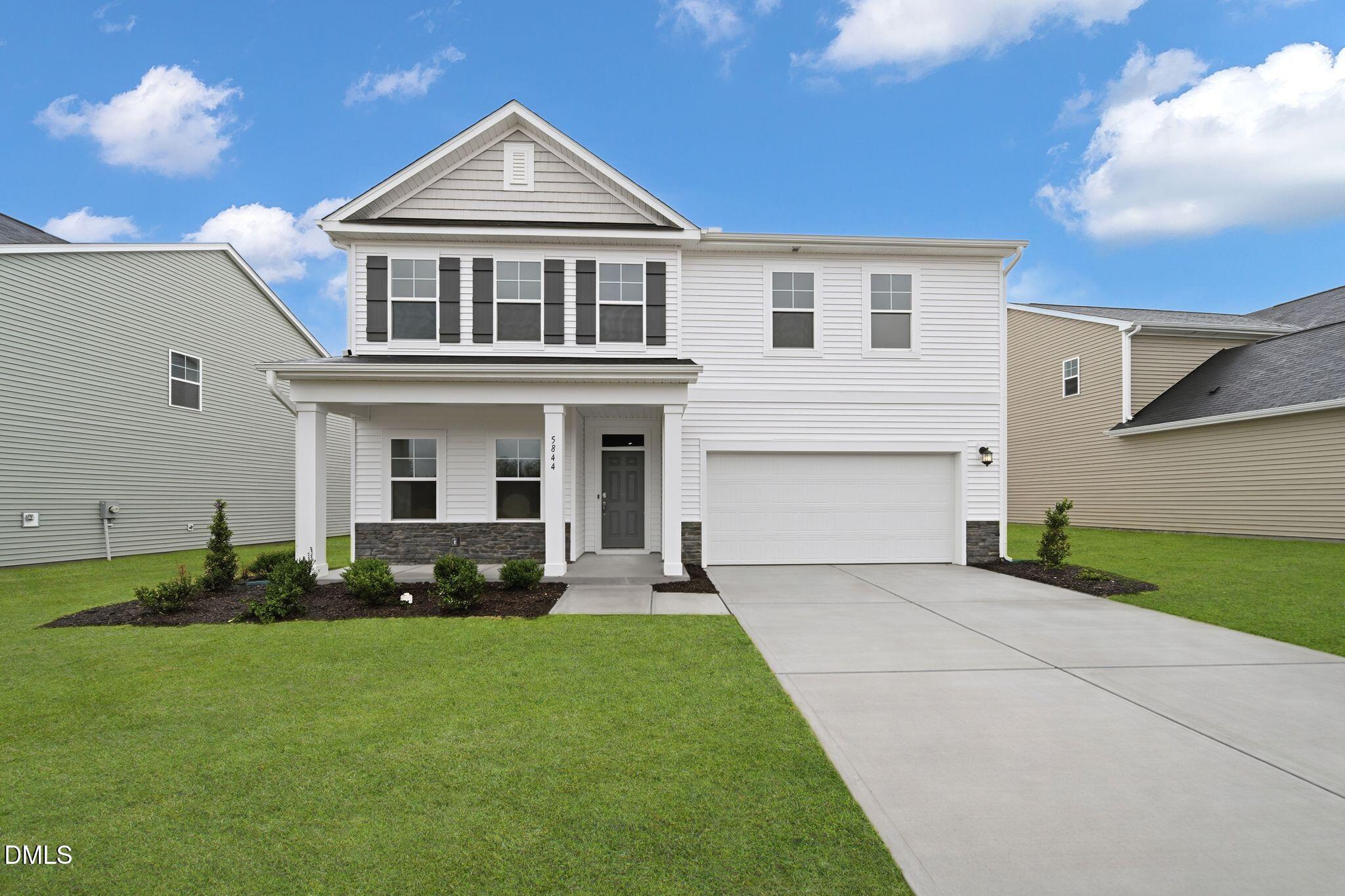 5844 Millstone Way Sims, NC 27880 - Photo 3 of 34 a front view of a house with a garden and yard
