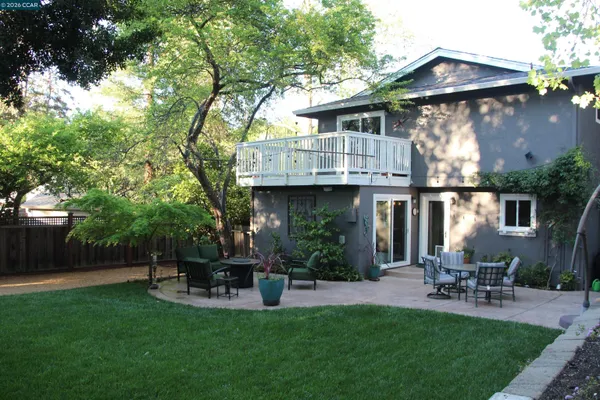 a view of house with backyard and outdoor seating