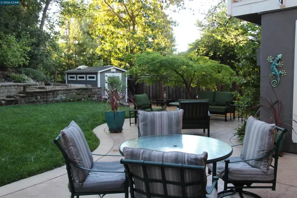 a view of a table and chairs in back yard of the house