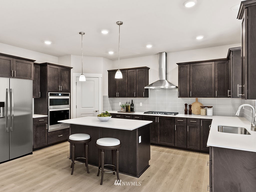 2 181st Street Southeast, Unit 12 Bothell, WA 98012 - Photo 6 of 23 a kitchen with stainless steel appliances granite countertop a sink a stove a refrigerator and chairs