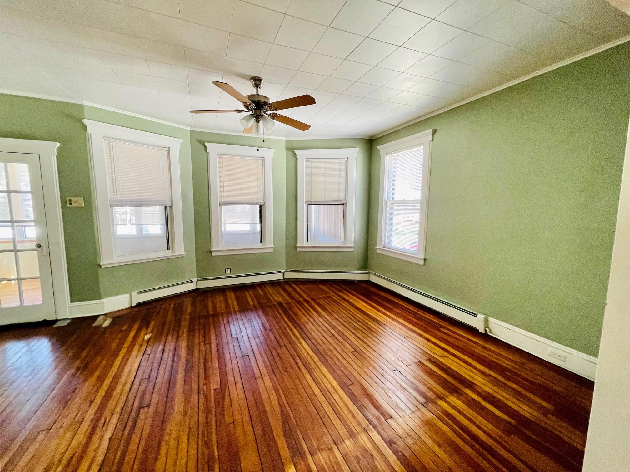 252 Murray Street, Unit 2 Elizabeth, NJ 07202 - Photo 4 of 14 a view of empty room with wooden floor and fan